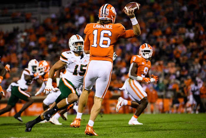 Oct 10, 2020; Clemson, South Carolina, USA; Clemson Tigers quarterback Trevor Lawrence (16) throws to running back Travis Etienne (9) against Miami Hurricanes defensive line Jaelan Phillips (15) during the first quarte at Memorial Stadium. Mandatory Credit: Ken Ruinard-USA TODAY Sports